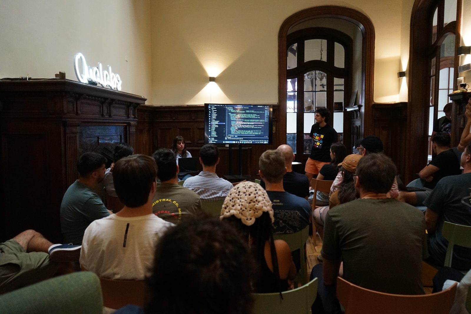 The room during the demo, watching code on screen while a camper presents