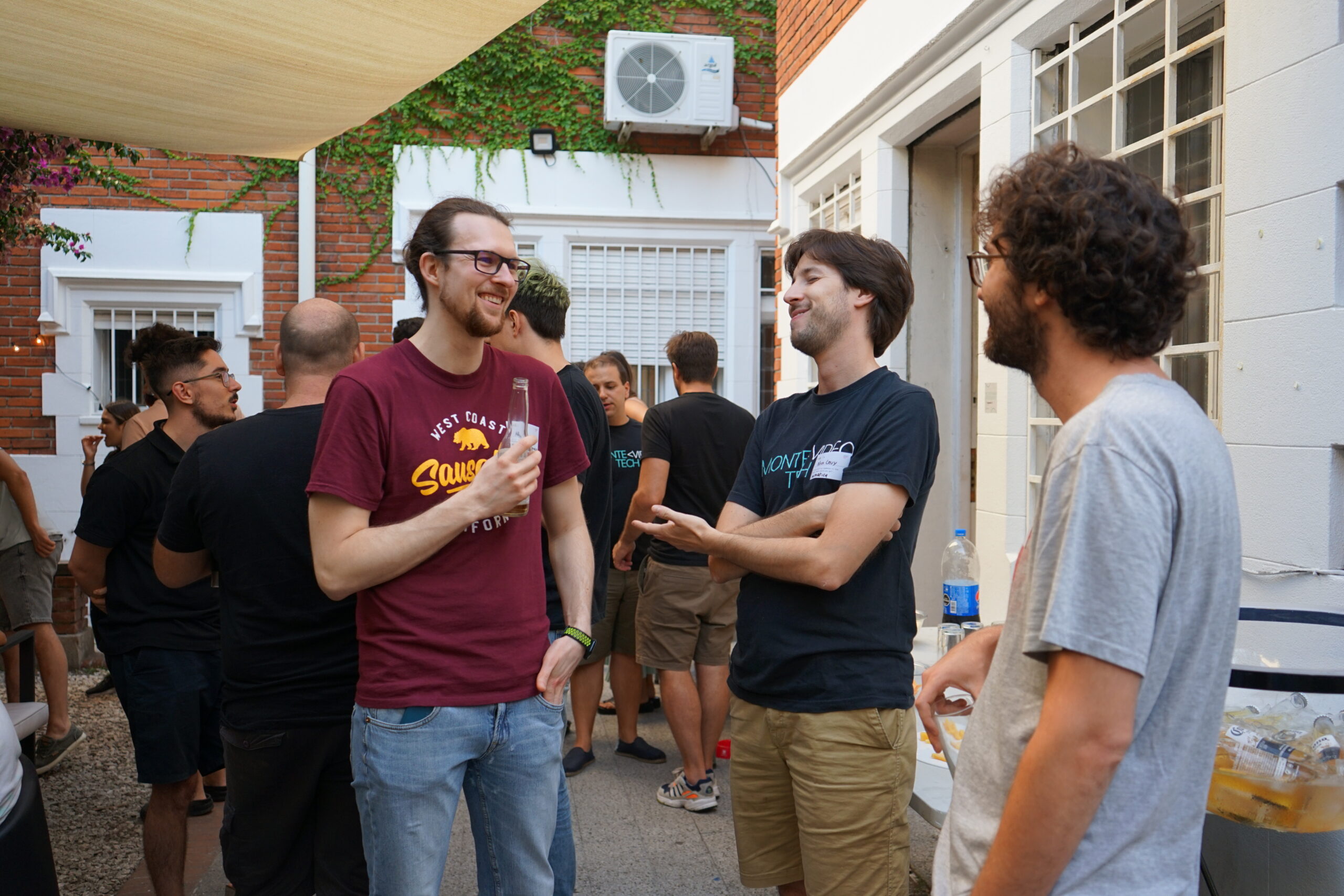 Attendees chatting with drinks at an outdoor MonteVIDEO Tech event