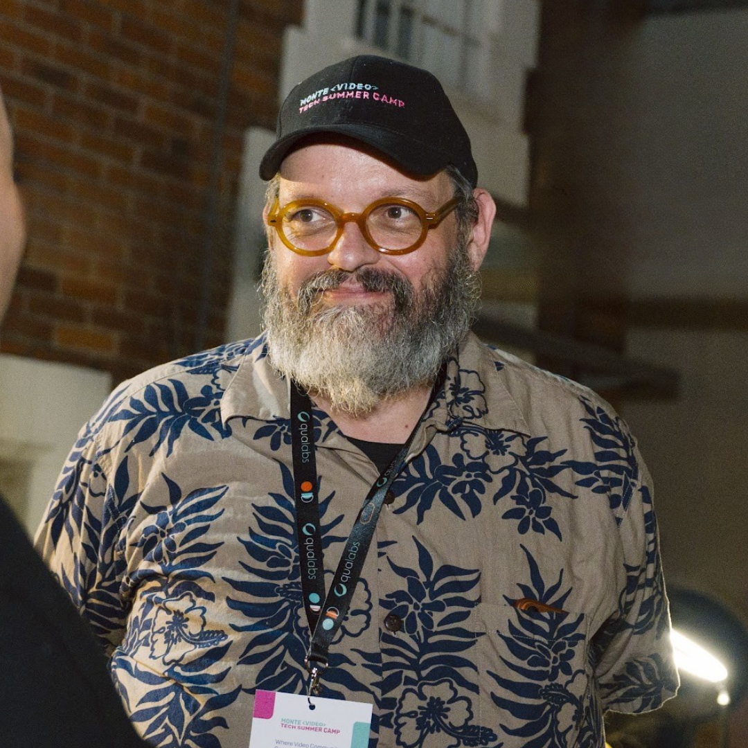 Andy Beach speaking at a MonteVIDEO Tech event, wearing a Summer Camp cap