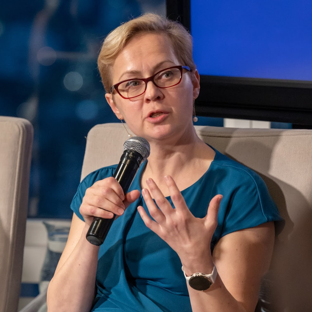 Olga Kornienko speaking into a microphone during a panel discussion